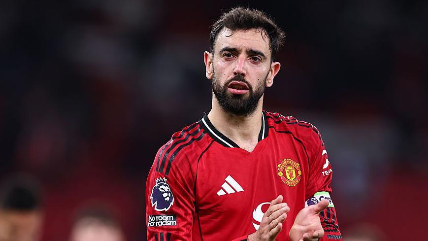 Bruno Fernandes applauding while wearing Manchester United match kit