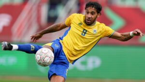Pierre-Emerick Aubameyang, seen wearing a yellow Gabon shirt with a blue number nine on the chest and blue shorts, attempts to volley a football with his right leg extended